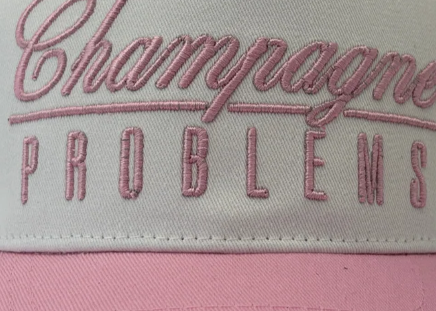 Cap with 'Champagne Problems' text on a white background
